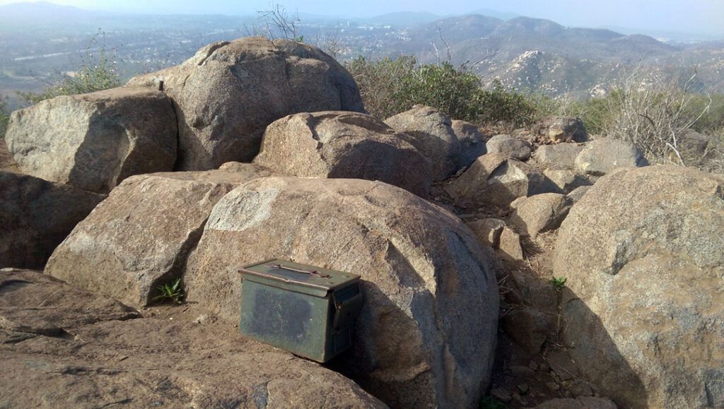 A hiker box marks the summit overlooking the valley below.