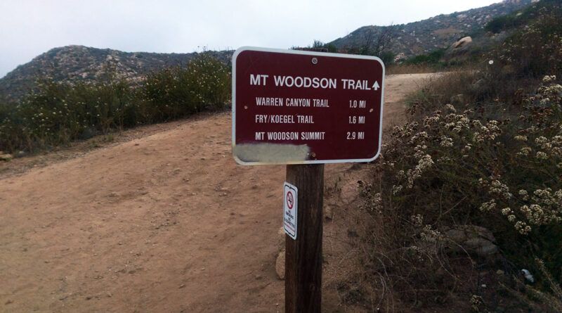 A sign indicating mileage and points of interest for Mount Woodson Trail to Potato Chip Rock.