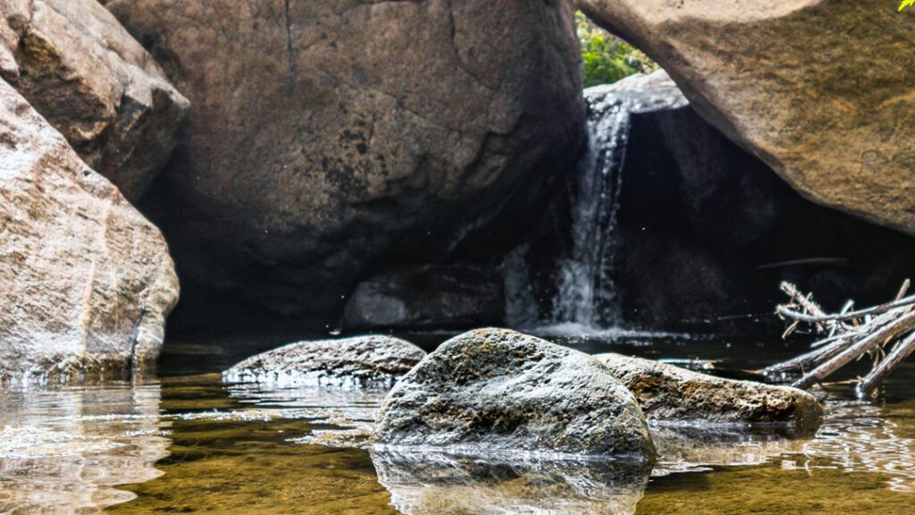 A small waterfall flowing between large boulders.