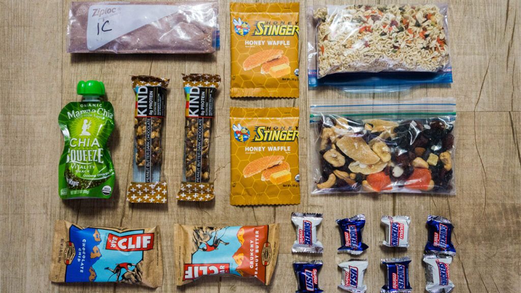 A full day of backpacking food organized and layed out on the floor.