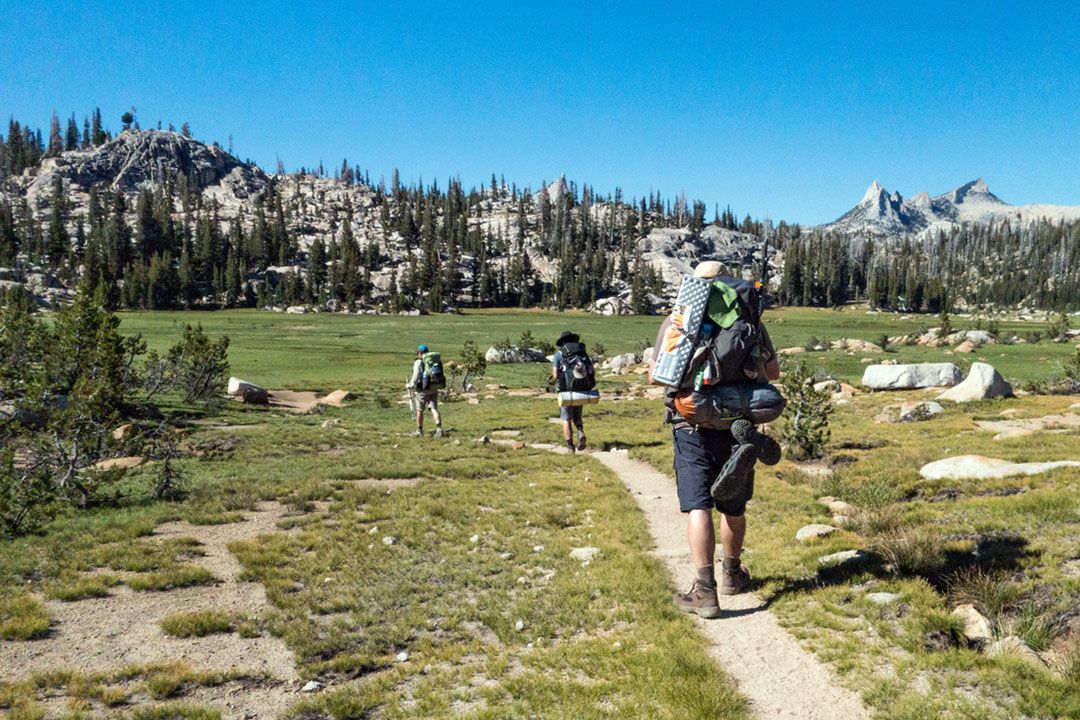 Three hikers on the JMT, hiking towards Sunrise Lakes campground.