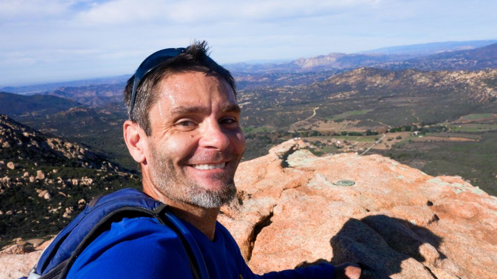 Robb Keele sitting on top of Lawson Peak in Cleveland National Forest