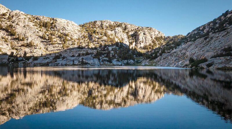 A reflective lake surrounded by mountains on the JMT