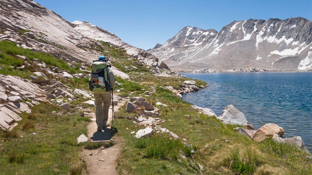 Backpacker hiking near a lake on the JMT